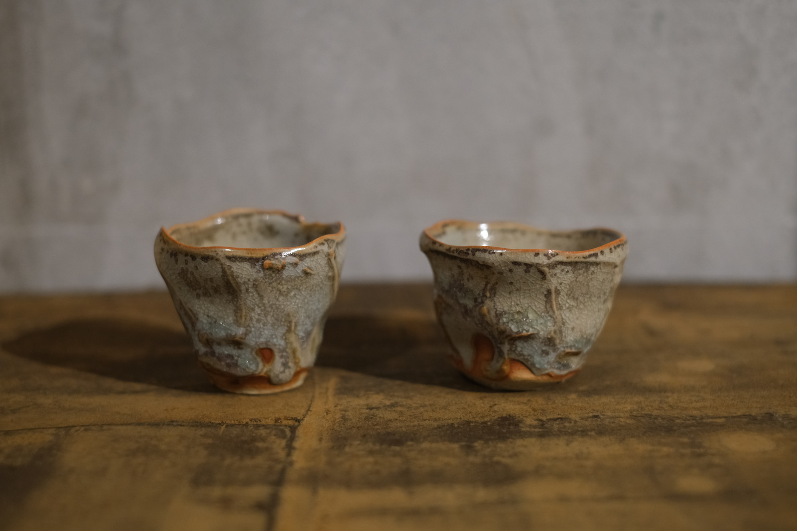 small cups with wavy carved sides. The glaze is matte and g
          reenish-grey. It breaks to a warm brown on edges.