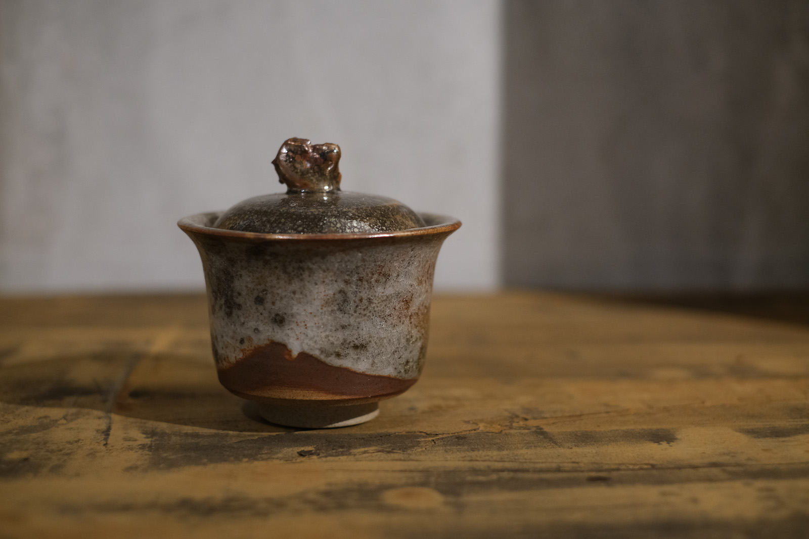 a greyish red gaiwan with a rough, stonelike nob on the lid