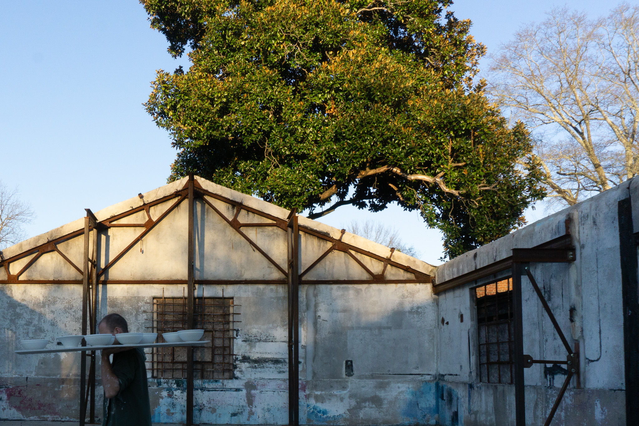 me, walking across a courtyard carying pots