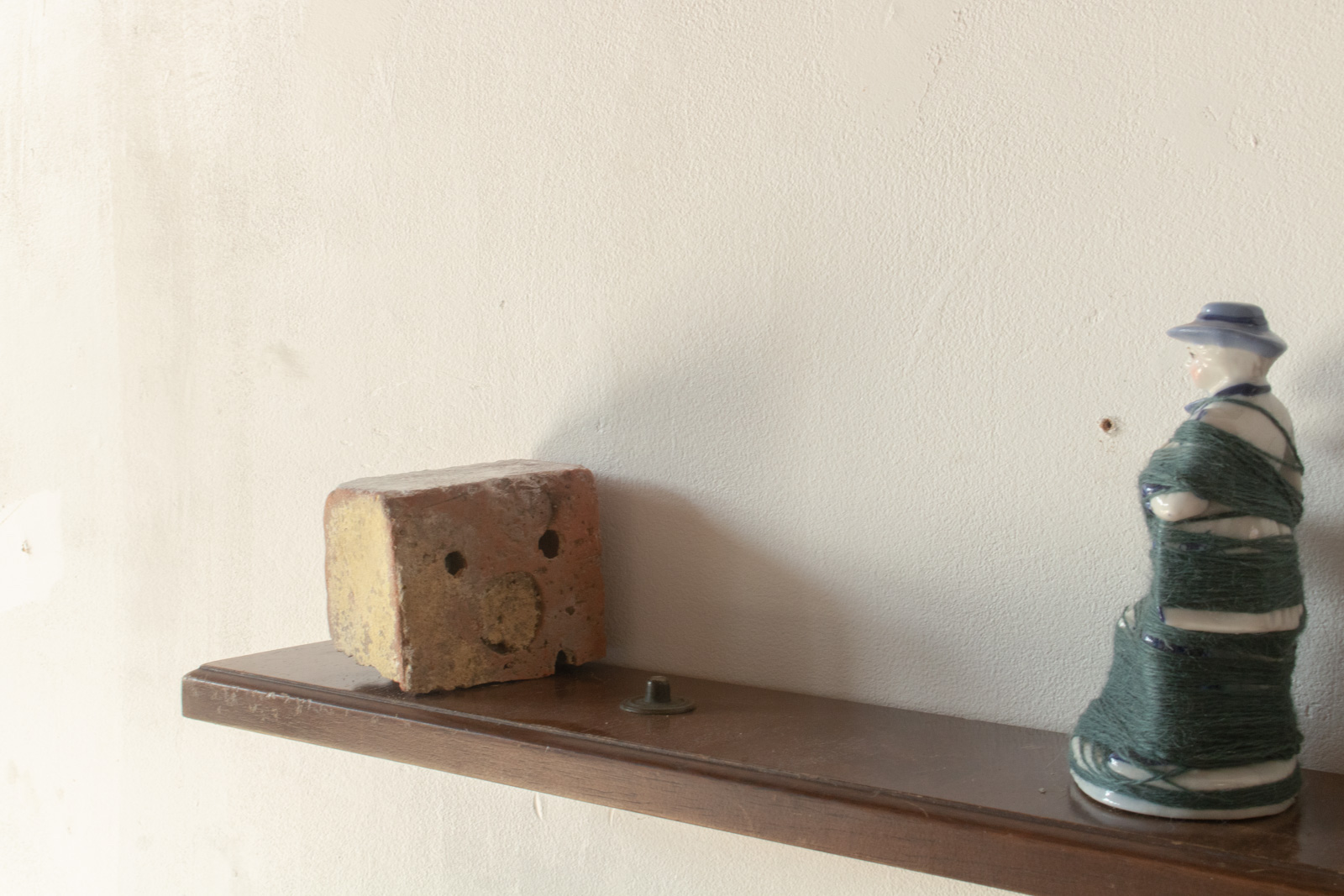 a view of the brick the couple are facing. The holes in the brick resemble a face with its mouth open.